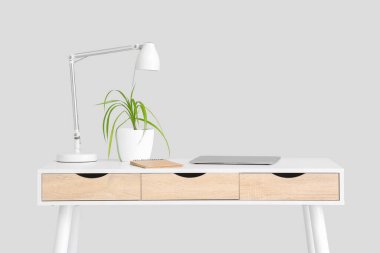 Beyaz arka planda lamba ve çiçek bulunan şık masa