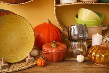 Farklı yemekler, sonbahar dekoru ve mutfaktaki ahşap masada mumlar.