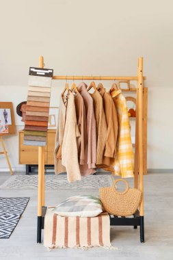 Moda tasarımcısının stüdyosunda kumaş örnekleri olan elbise askısı.