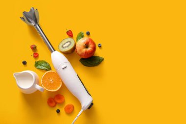 Sarı arka planda bir sürahi süt, meyve ve böğürtlen ile modern blender