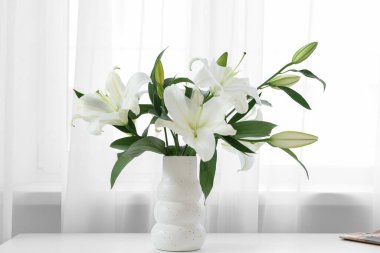 Vazo dolusu güzel beyaz zambak çiçekleri evdeki masada.