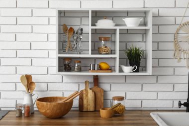 Tezgahlarda ve raflarda farklı tabaklar olan aydınlık mutfağın içi, yakın plan.