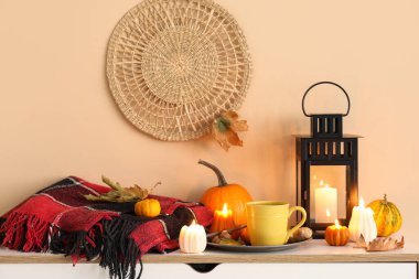 Bir fincan yeşil çay, mumlar, ekose ve fener oda çekmecesinde.