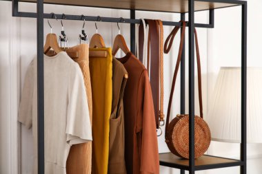 Modern soyunma odasının içinde raflarda şık kıyafetler, yakın çekim.