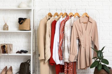 Soyunma odasındaki beyaz tuğla duvarın yanındaki rafları ve elbiseleri topla.