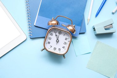 Alarm saati, kırtasiye ve tablet bilgisayarlı renk arkaplanı bileşimi