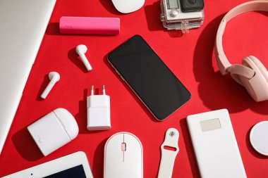 Kırmızı arkaplan, üst görünümde modern aygıtlar kümesi