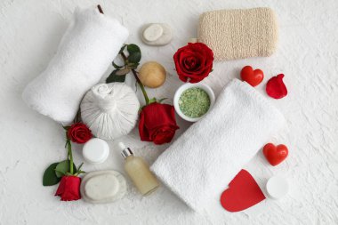 Spa aksesuarlı kompozisyon, kırmızı gül çiçekleri ve açık arkaplanda kalpler. Sevgililer Günü kutlaması