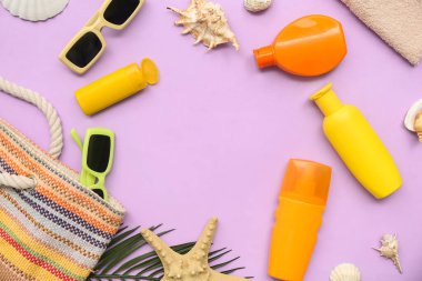 Güneş kremi şişelerinden yapılmış çerçeve, deniz kabukları, çanta ve leylak arkaplanda güneş gözlüğü