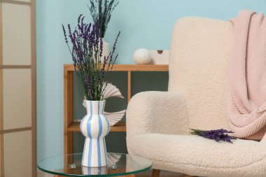 Oturma odasındaki masada lavanta çiçekli vazo.