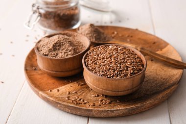 Beyaz ahşap arka planda keten tohumu ve un kaseleri