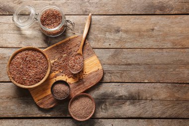 Keten tohumlu kavanoz ve ahşap zemin üzerinde un kaseleri.