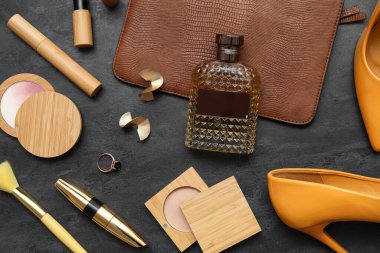 Kozmetik ürünleri, aksesuarlar, parfümler ve siyah arka planda küpeler. Yakın çekim.