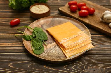 Lezzetli işlenmiş peynir dilimleri ve ahşap masada ıspanak.