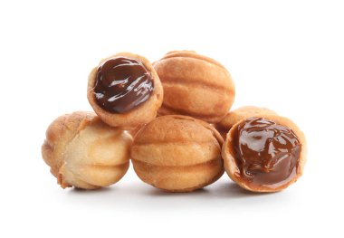 Beyaz arka planda kaynamış konsantre sütle pekçok tatlı ceviz şekilli kurabiye.