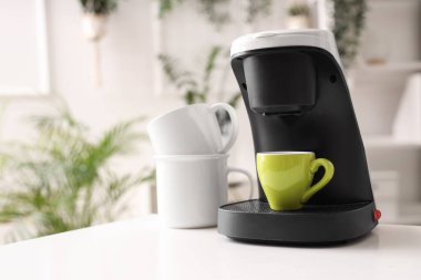 Ofisteki masada fincanlı kahve makinesi, yakın plan.