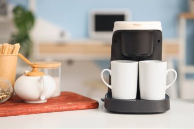 Ofisteki masada fincanlı kahve makinesi, yakın plan.