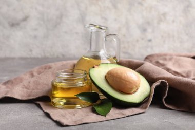 Gri zemin üzerinde avokado yağı olan kompozisyon