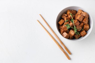 Beyaz arka planda kızarmış tofu peyniri ve mikro yeşil tabakla.