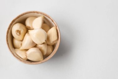 Beyaz arka planda taze sarımsaklı karanfil kasesi