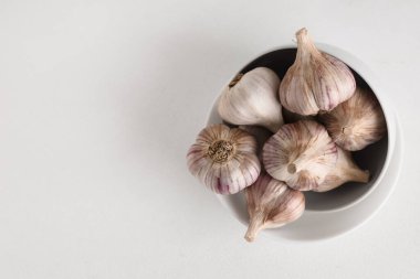 Beyaz arka planda taze sarımsaklı kase