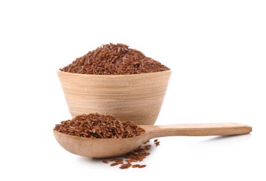 Tahta kase ve kaşık, beyaz arka planda çiğ kahverengi pirinç.