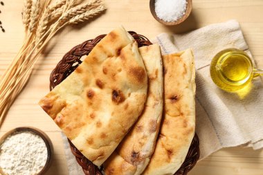 Tahta arka planda lezzetli lahanalar, malzemeler ve buğday dikenleriyle dolu bir sepet.