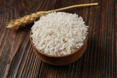 Çiğ pirinç ve ahşap zemin üzerinde buğday kasesi