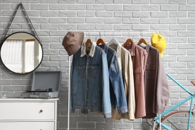 Ayna, çekmece sandığı ve koridorun iç tarafında giysi olan askılar.