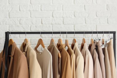 Beyaz tuğla duvarın yanında şık elbiselerle dizilin.