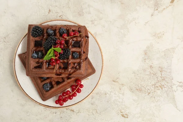 Beyaz arka planda taze böğürtlen ve nane şekerli Belçika Waffle tabağı.