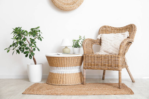Armchair, houseplant and coffee table with lamp in interior of living room
