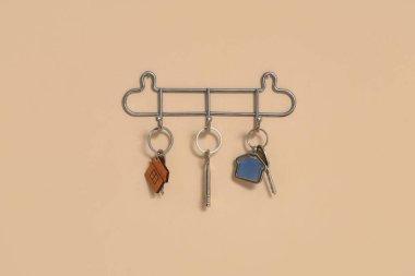 Evin anahtarları bej duvarda asılı.