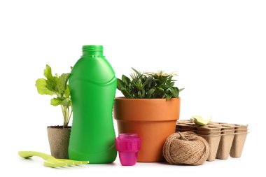 Bir şişe bitki gübresi ve beyaz arka planda bahçe malzemeleri.