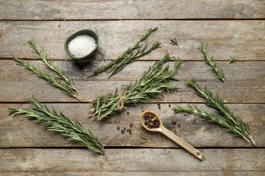 Biber taneli taze biberiye dalları ve ahşap arka planda bir kase tuz.