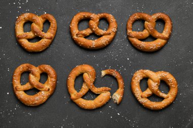 Siyah arkaplanda tuzlu krakerler, yakın plan.