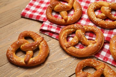 Ahşap arka planda peçete ve lezzetli krakerler, yakın plan.