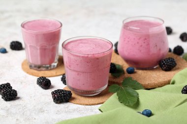 Beyaz arka planda taze böğürtlen suyu ve yaban mersini.