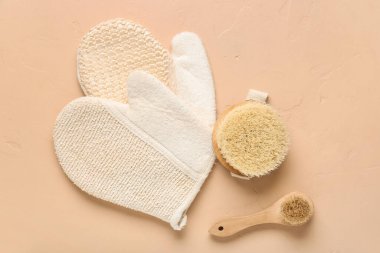Bej arka planda vücut masajı fırçaları ve eldivenleri