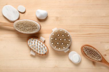 Tahta arka planda vücut masajı fırçaları ve spa taşları