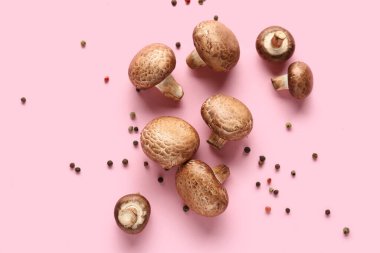 Taze çiğ mantar ve pembe arka planda biber.