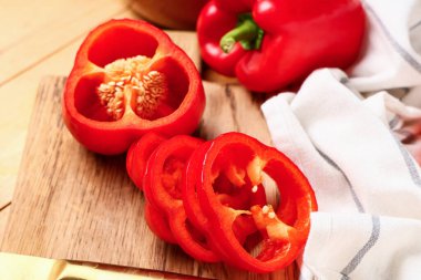 Tahta kesme tahtası, ahşap arka planda kırmızı dolma biber, yakın plan.