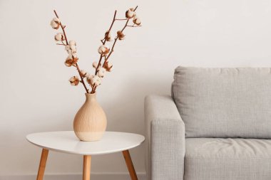 Oturma odasındaki masada pamuk çiçekli vazo, yakın plan.