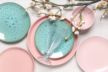 Beyaz zemin üzerinde cam ve çiçek açan dallarla farklı temiz tabakalar.