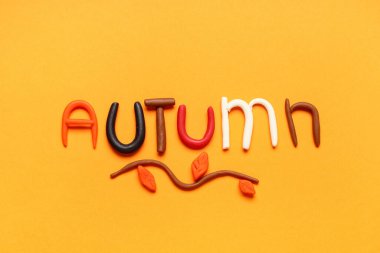Kelime AUTUMN sarı arka planda hamur oynamaktan yapılır