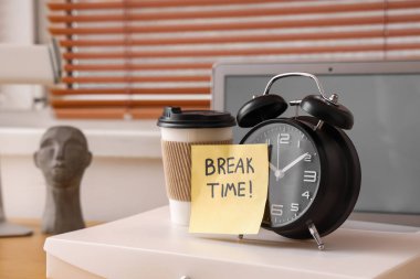 Ofisteki klasörde metin kırma saati, alarm saati ve kahve fincanı olan kağıt.