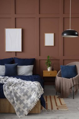 Şık yatak odasının içinde lacivert keten, masa ve koltuk.