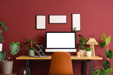 İşyeri, boş çerçeveler ve ev bitkileri olan şık bir ofis.