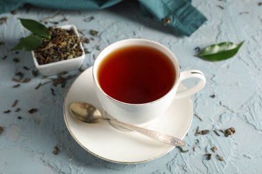 Mavi grunge arka planda bir fincan lezzetli siyah çay, yakın plan.