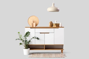 Beyaz arka planda kitap ve heykelcikler olan çekmeceler.